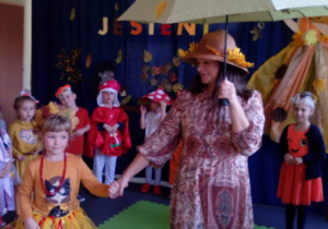 Pani Jesień z dziewczynką pod parasolem wśród dzieci.